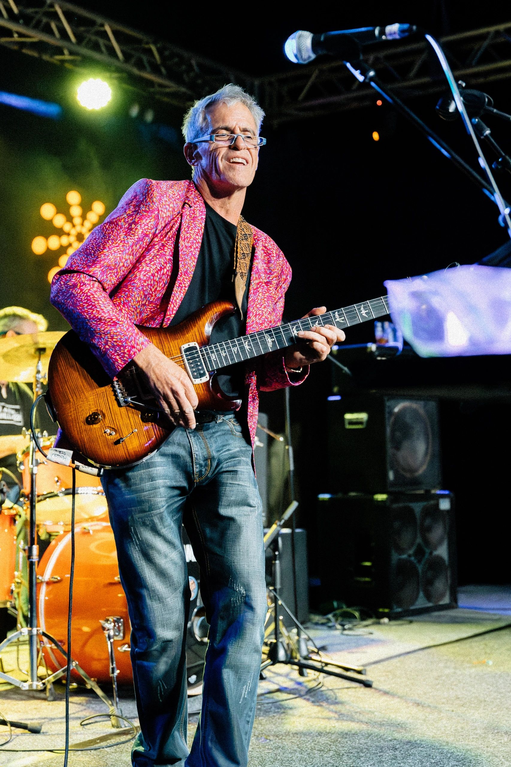 Groove Dr B with his electric guitar in a warm studio light